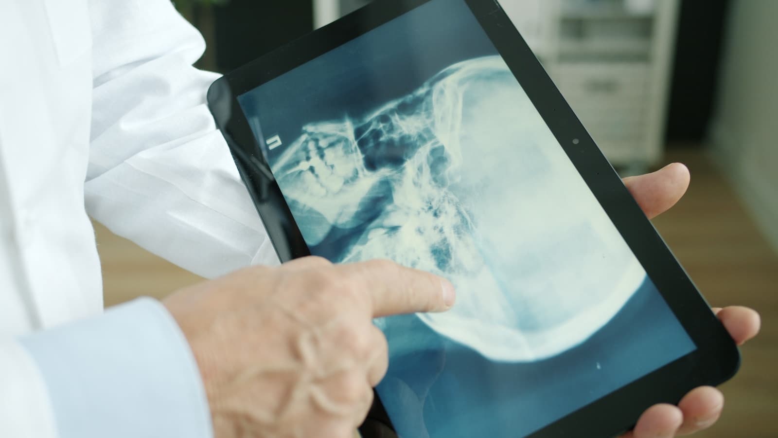 Doctor pointing at an x-ray on a tablet screen