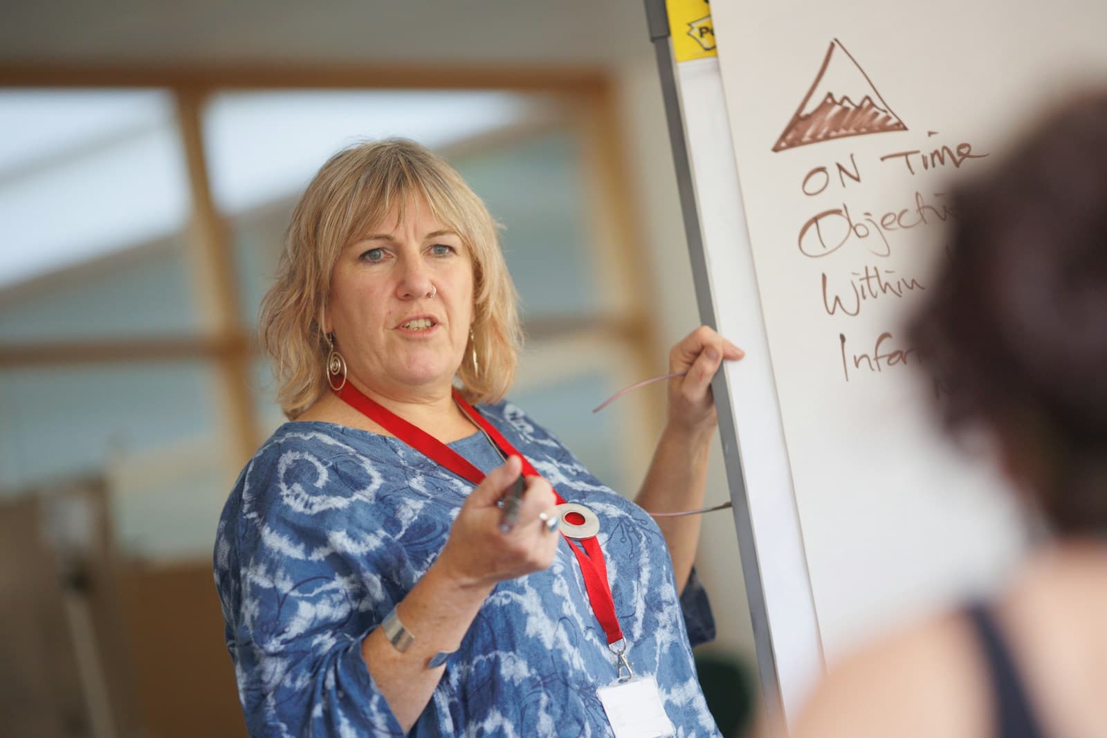 Person writing on a whiteboard in a classroom